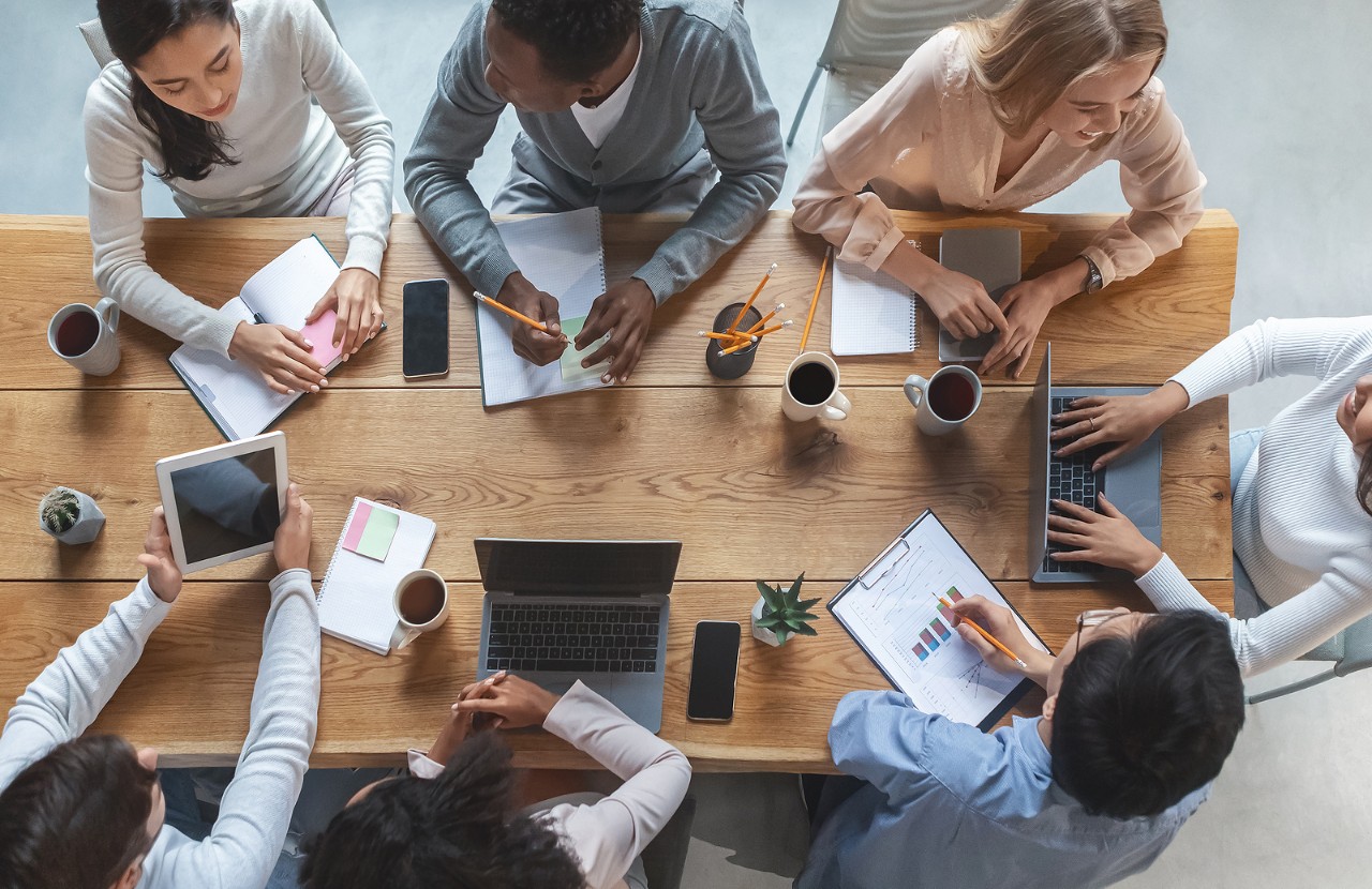 Office Lifestyle Concept. Top View Of International Young Business Team Having Meeting At Office, Si Office lifestyle concept. Top view of international young business team having meeting at office, sitting around table