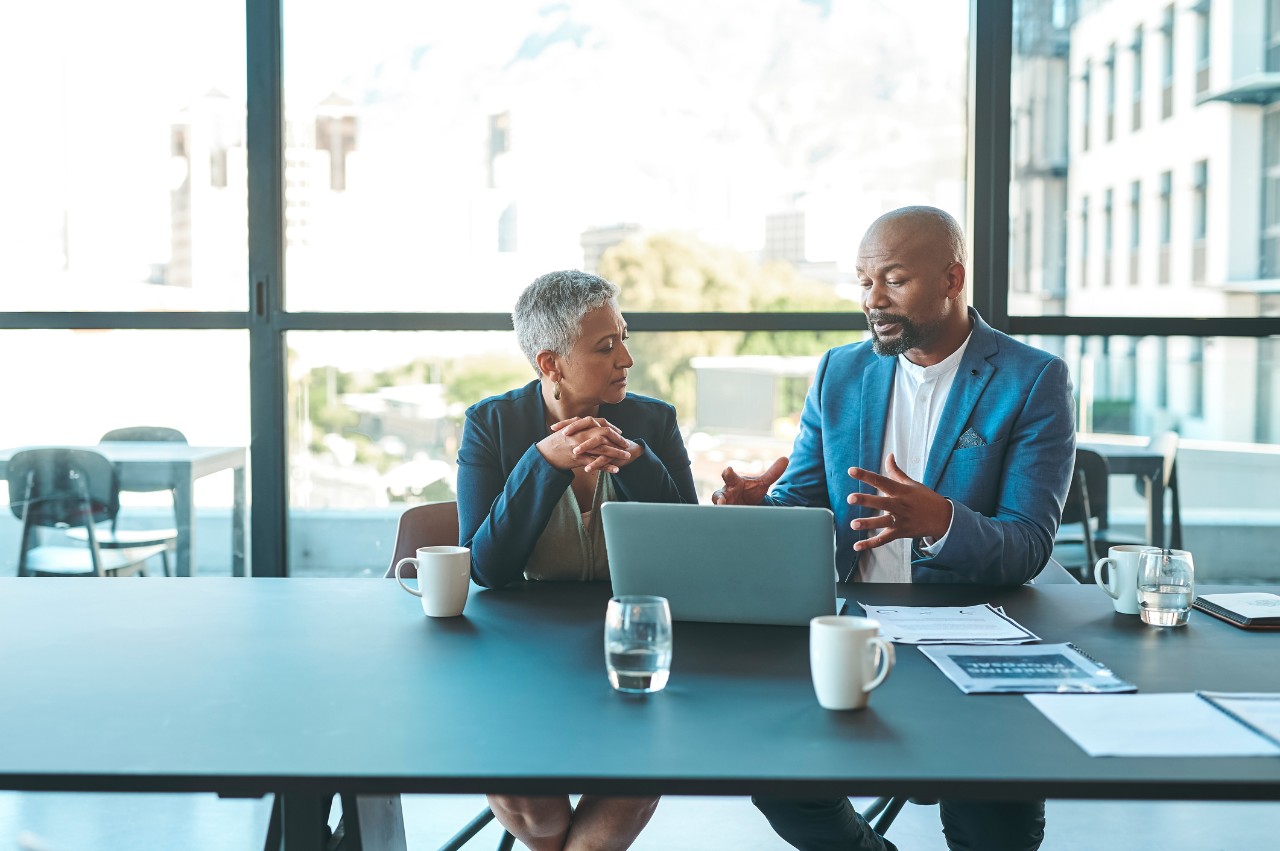 1419539600 Business, presentation and man on a laptop in a corporate conference or office collaboration with a woman at work. Businessman, manager or coach for marketing, strategy and sales working with CEO.